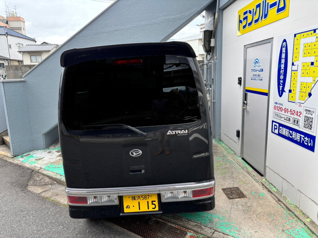 店舗前の駐車スペースに停車した車とトランクルーム看板｜広島府中町大通店