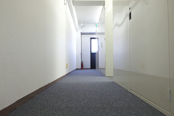 トランクルーム松戸二ツ木店の明るく清潔な屋内廊下(絨毯敷き)