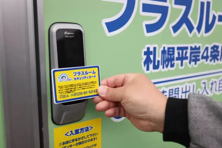 トランクルーム札幌平岸4条店の入口で、セキュリティカードを電子錠にかざして入室する様子