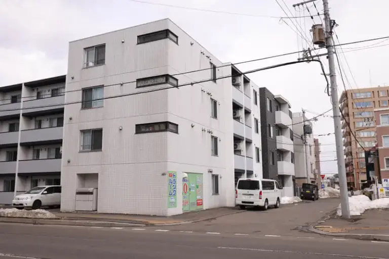 札幌市豊平区平岸4条にある屋内型トランクルーム「プラスルーム札幌平岸4条店」が入る4階建ての白い建物の全景