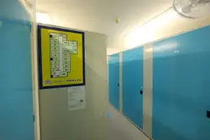 プラスルーム札幌厚別東店の屋内通路。青い扉のトランクルームが並び壁にフロアマップを掲示